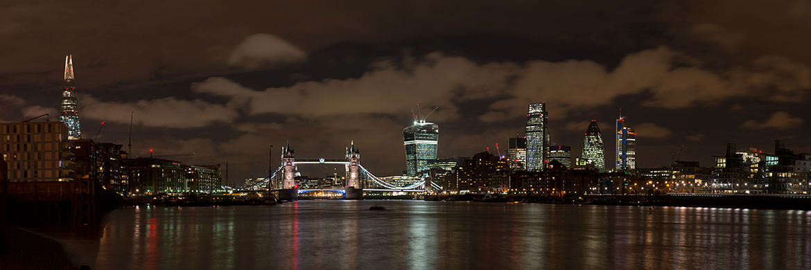 City of London panorama featuring  the new City skyline beneath rain clouds at night.