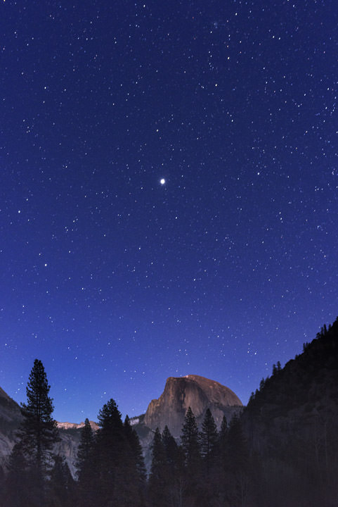 Jupiter dominates a star studded sky over Yosemite at night.