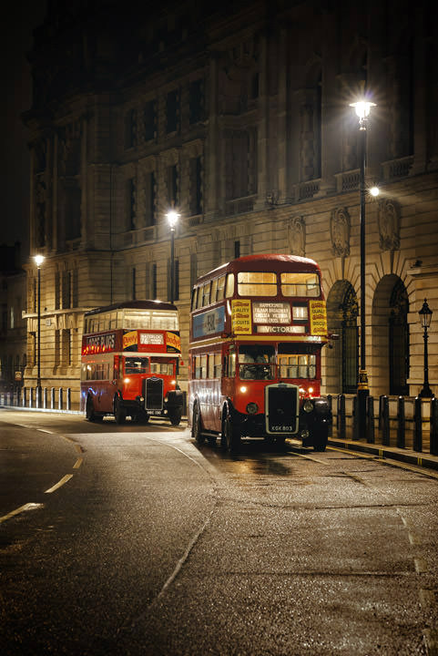 Two vintage buses on a wet night  in London