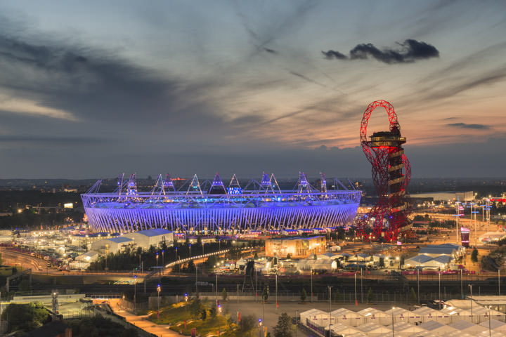 Queen Elizabeth II Olympic Stadium in purple and red at dusk