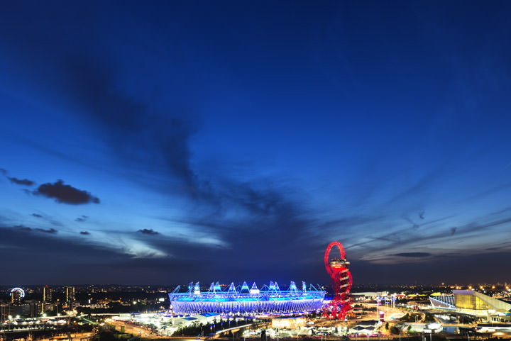 Queen Elizabeth II Olympic Stadium - London Stadium brightly lit beneath a deep blue sky