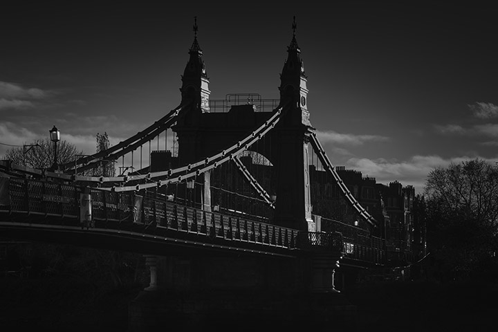 A moody photograph showing the glints of Last Light at Hammersmith Bridge