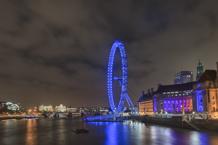 London Eye in blue and County Hall in blue orange and purple at night